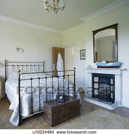Wooden chest below brass bed in coungtry bedroom with fireplace View Large Photo Image Picture - Wooden chest below brass bed in coungtry bedroom with fireplace. Fotosearch