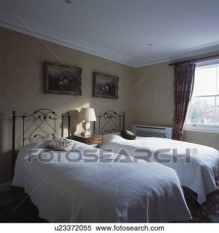 Wrought-iron twin beds in small traditional bedroom View Large Photo Image Stock Photography - Wrought-iron twin beds in small traditional bedroom. Fotosearch