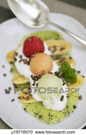 Stock Image - Baby Banana Split with Kiwi Puree, mixed fruit sorbets and cream. Fotosearch