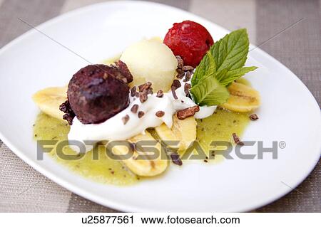 Stock Image - Baby Banana Split with Kiwi Puree, fruit sorbet and whipped cream. Fotosearch