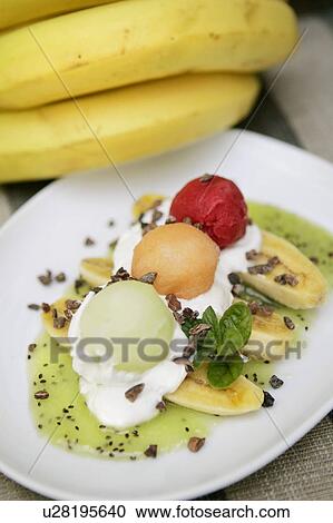 Stock Image - Baby Banana Split with Kiwi Puree, fruit sorbet and whipped cream. Fotosearch