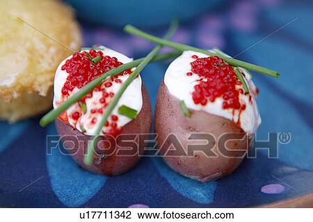 Stock Image - Baby New Potatoes with cream, chives and roe. Fotosearch