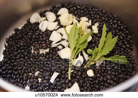 Picture - Black Velvet Beans in pot with Epazote Herbs. Fotosearch