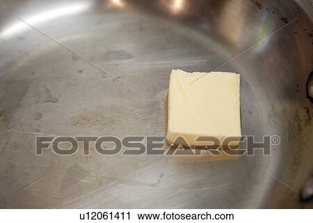 Stock Image - Butter melting in Pan. Fotosearch