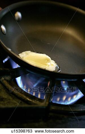 Stock Image - Butter melting in Pan. Fotosearch