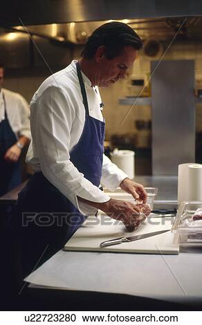Stock Image - Chef preparing meat. Fotosearch