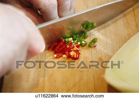 Picture - Chopping green and red chilies. Fotosearch