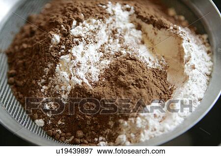 Stock Photo - Cocao and Flour in sieve /step shot. Fotosearch