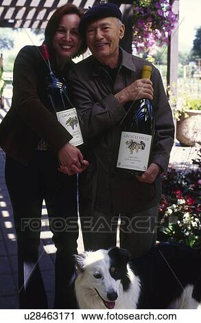 Stock Image - Man and woman with large bottles with wine. Fotosearch