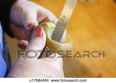 Picture - Peeling a Kiwifruit. Fotosearch