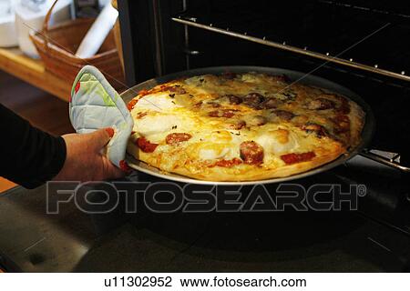 Stock Image - Pepperoni Pizza in the oven. Fotosearch