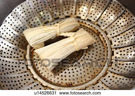 Stock Image - Preparing Tamale in Corn Husks / step shot. Fotosearch