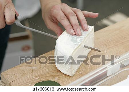 Stock Image - Slicing Camembert Cheese. Fotosearch