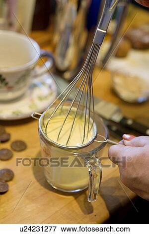 Stock Photo - Whisking Custard through Sieve. Fotosearch