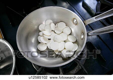Stock Image - White Chocolate rounds in pan. Fotosearch