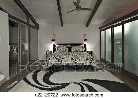 Stock Image - Bedroom with rug and sliding door in luxury manor house. Fotosearch