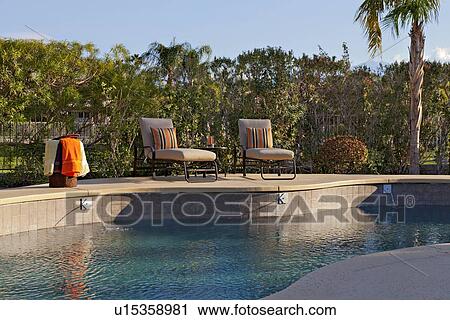 Chaise lounge chairs at poolside of manor house View Large Photo Image Stock Image - Chaise lounge chairs at poolside of manor house. Fotosearch