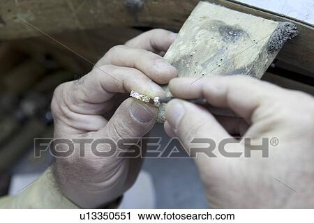 Stock Image - Close-up of a mature man's hand repairing ring. Fotosearch
