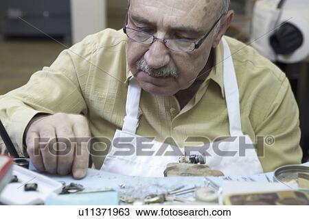 Close-up of a young worker concentrating on repairing jewelry in workshop View Large Photo Image Stock Image - Close-up of a young worker concentrating on repairing jewelry in workshop. Fotosearch