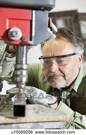 Close-up of mature man wearing protective eyewear concentrating on work View Large Photo Image Stock Photo - Close-up of mature man wearing protective eyewear concentrating on work. Fotosearch
