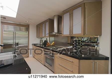 Stock Image - Contemporary kitchen counter and stove in mansion. Fotosearch