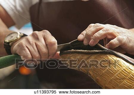 Stock Photography - Cropped image of shoemaker cutting edge of sole. Fotosearch