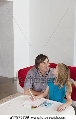 Father and daughter looking at each other while doing homework together View Large Photo Image Stock Photo - Father and daughter looking at each other while doing homework together. Fotosearch