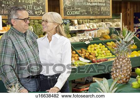 Happy couple standing in farmer's market View Large Photo Image Stock Image - Happy couple standing in farmer's market. Fotosearch