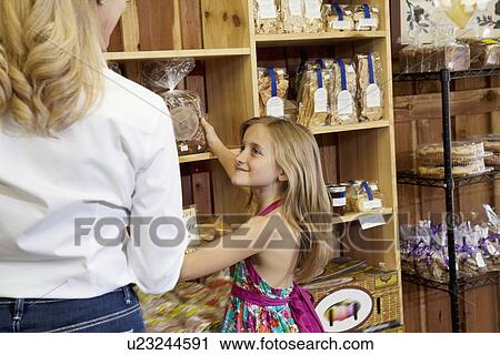 Happy girl selecting bread with grandmother in market View Large Photo Image Stock Image - Happy girl selecting bread with grandmother in market. Fotosearch