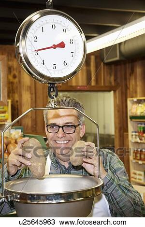 Happy mature man measuring potato in weight scale View Large Photo Image Stock Image - Happy mature man measuring potato in weight scale. Fotosearch