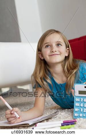 Happy young elementary aged girl doing homework View Large Photo Image Stock Photo - Happy young elementary aged girl doing homework. Fotosearch
