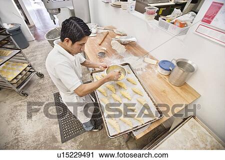 High angle view of young baker preparing bread in bakery View Large Photo Image Stock Image - High angle view of young baker preparing bread in bakery. Fotosearch
