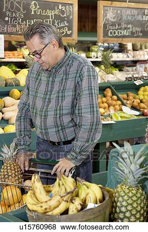 Stock Photo - Mature man shopping in farmer's market. Fotosearch