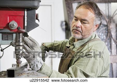 Mature metalworker working with machinery in workshop View Large Photo Image Stock Image - Mature metalworker working with machinery in workshop. Fotosearch