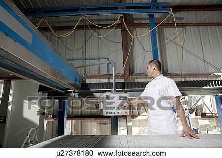 Mid adult industrial worker operating machinery in factory View Large Photo Image Stock Image - Mid adult industrial worker operating machinery in factory. Fotosearch