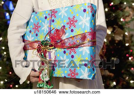 Midsection of girl holding birthday gift View Large Photo Image Stock Photograph - Midsection of girl holding birthday gift. Fotosearch