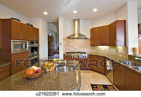 Stock Image - Modern kitchen with fruits on counter in manor house. Fotosearch