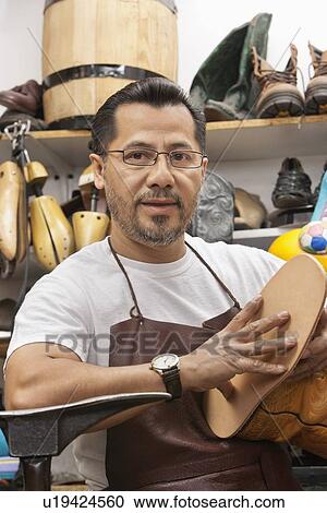 Portrait of a confident cobbler with shoe sole in workshop View Large Photo Image Stock Image - Portrait of a confident cobbler with shoe sole in workshop. Fotosearch