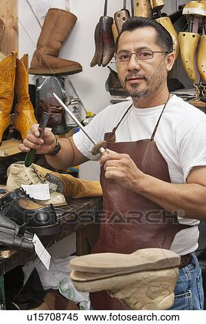 Portrait of a confident cobbler working on working on shoe sole in workshop View Large Photo Image Stock Photography - Portrait of a confident cobbler working on working on shoe sole in workshop. Fotosearch