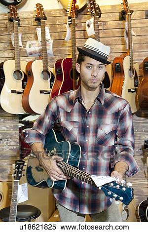 Portrait of a confident customer with guitar in music store View Large Photo Image Stock Photography - Portrait of a confident customer with guitar in music store. Fotosearch
