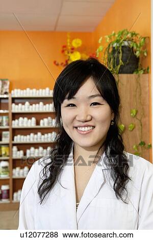 Portrait of a happy Asian employee in drugstore View Large Photo Image Stock Photo - Portrait of a happy Asian employee in drugstore. Fotosearch