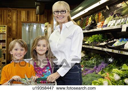 Stock Photo - Portrait of a happy children with grandmother standing in farmer's market. Fotosearch