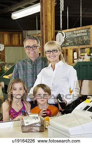 Portrait of a happy grandparents with children standing at checkout counter in market View Large Photo Image Stock Photograph - Portrait of a happy grandparents with children standing at checkout counter in market. Fotosearch