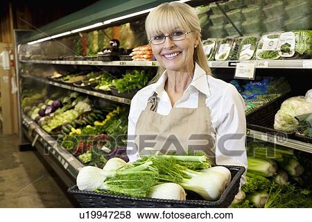 Portrait of a happy senior woman carrying bok choy in vegetable market View Large Photo Image Stock Photo - Portrait of a happy senior woman carrying bok choy in vegetable market. Fotosearch