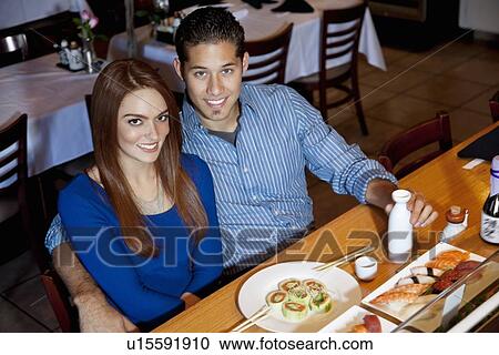 Portrait of a happy young couple eating Japanese cuisine in restaurant View Large Photo Image Stock Image - Portrait of a happy young couple eating Japanese cuisine in restaurant. Fotosearch