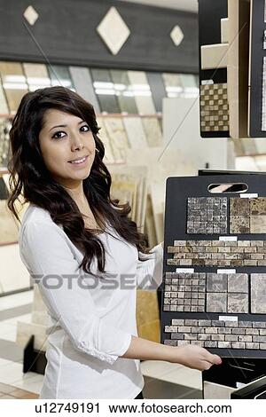 Portrait of a happy young owner showing sample tiles in store View Large Photo Image Stock Image - Portrait of a happy young owner showing sample tiles in store. Fotosearch