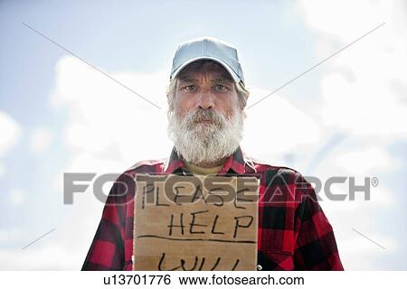 Stock Photograph - Portrait of a homeless person with sign. Fotosearch