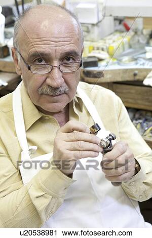 Portrait of a mature repair worker with loupe in workshop View Large Photo Image Stock Image - Portrait of a mature repair worker with loupe in workshop. Fotosearch
