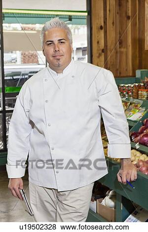 Portrait of a mid adult chef standing in market View Large Photo Image Stock Photo - Portrait of a mid adult chef standing in market. Fotosearch