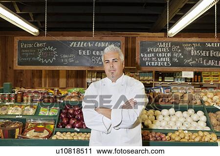 Stock Image - Portrait of a mid adult chef with arms crossed in farmer's market. Fotosearch